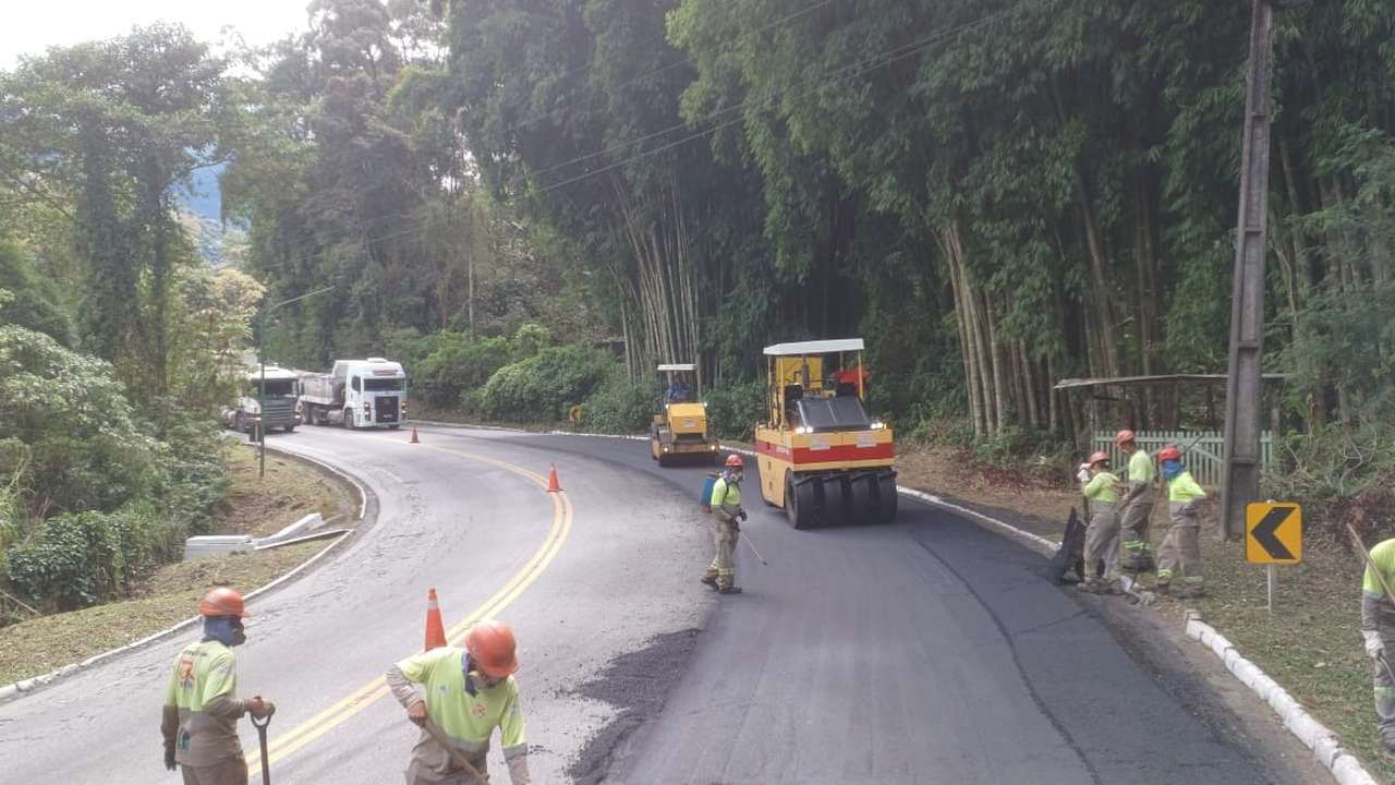 Obras de restauração na Serra dos Três Picos, Cachoeiras de Macacu, com máquinas e trabalhadores.