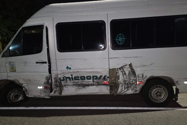 Ônibus branco danificado após acidente na RJ-116.