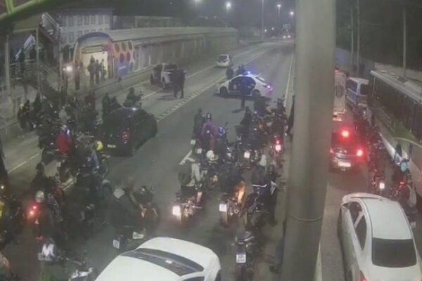 Operação policial na Avenida Brasil, com motos e ônibus parados.