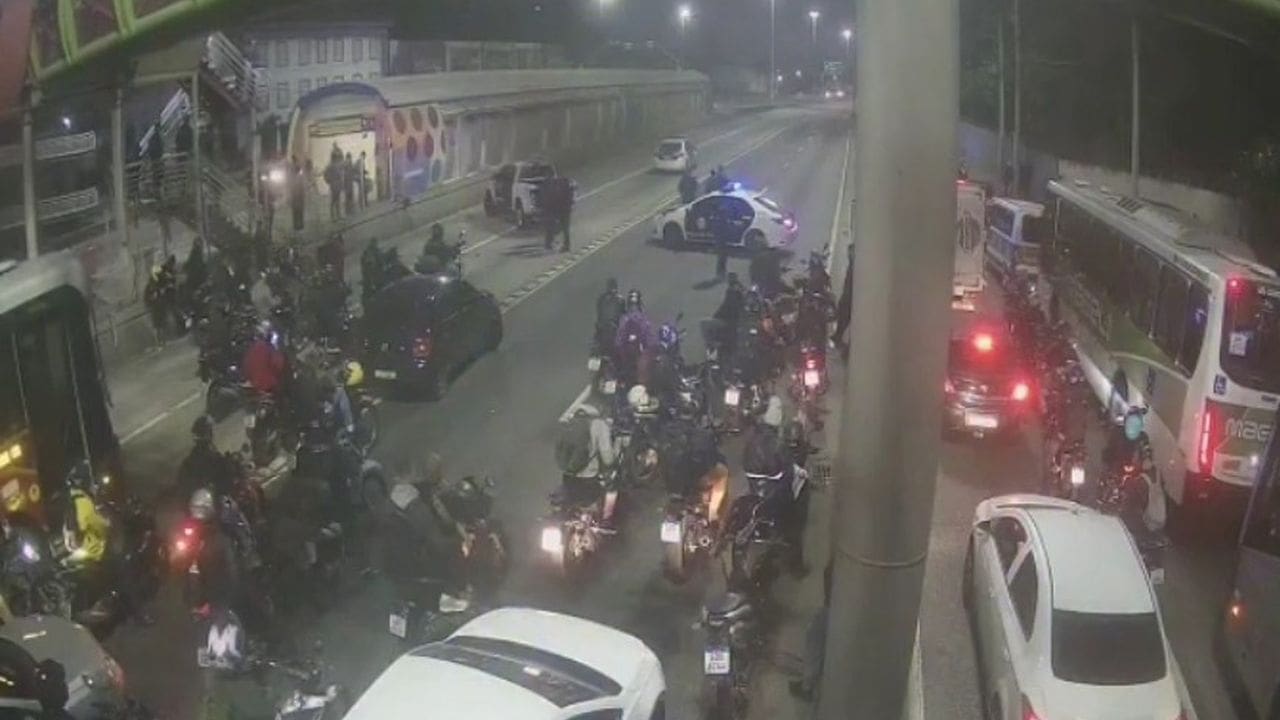 Operação policial na Avenida Brasil, com motos e ônibus parados.