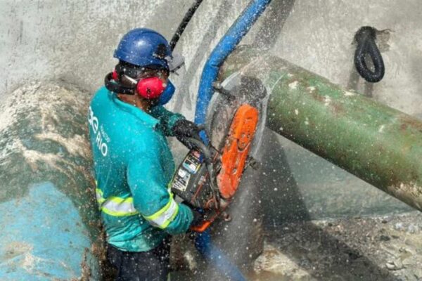 Operário corta cano em estação de tratamento de água