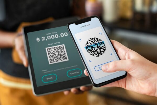 Pagamento com QR code: celular escaneando código em tablet para transação de $2.000.