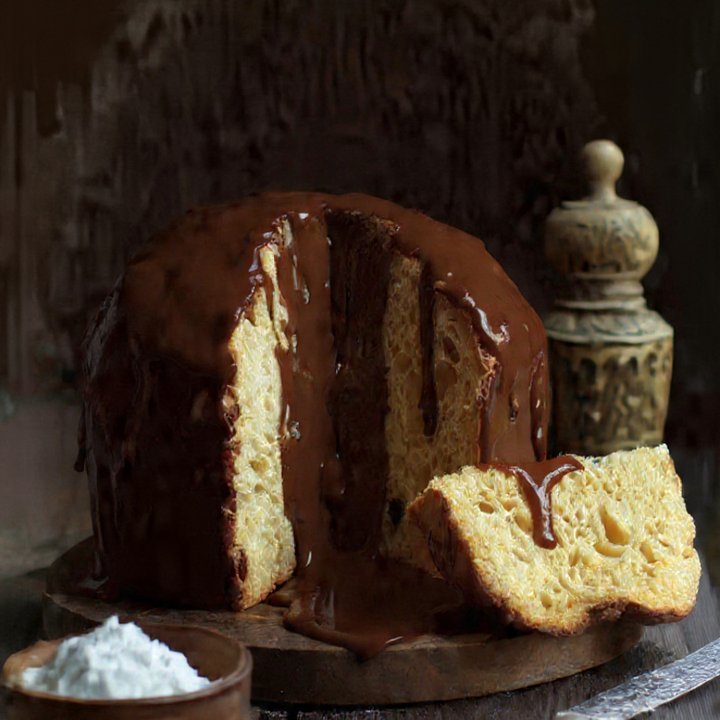 Panetone com cobertura de chocolate e fatia cortada.