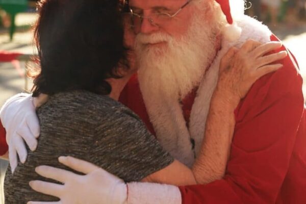 Papai Noel abraçando uma pessoa. Armando Gomes, eterno Papai Noel de Nova Friburgo.