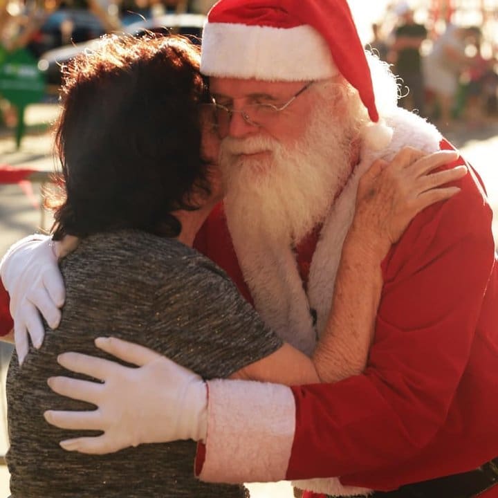 Papai Noel abraçando uma pessoa. Armando Gomes, eterno Papai Noel de Nova Friburgo.
