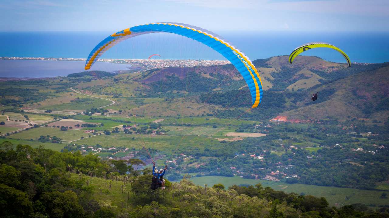 Parapentes sobre paisagem em Saquarema