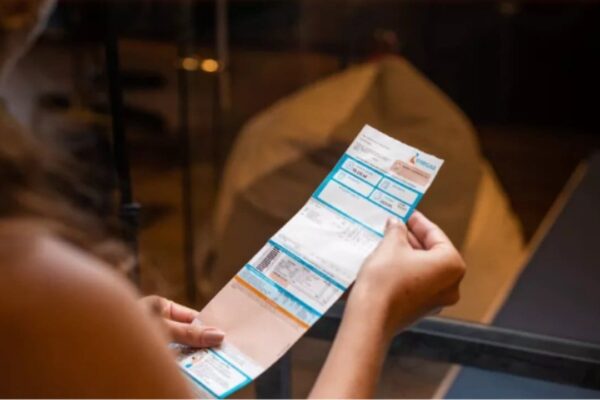 Pessoa segurando conta da Energisa, que oferece negociação digital de débitos.