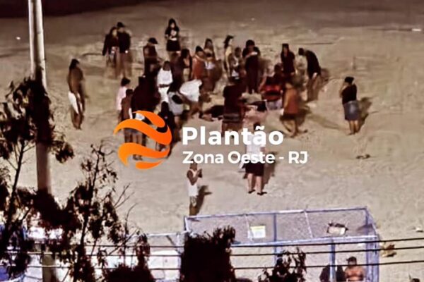Pessoas em uma praia à noite, com um logotipo 'Plantão Zona Oeste - RJ' sobreposto.