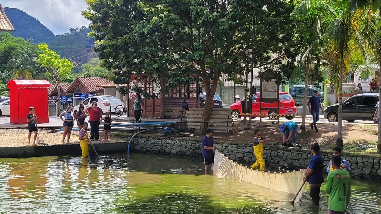Pessoas limpando o lago de Lumiar, em Nova Friburgo.
