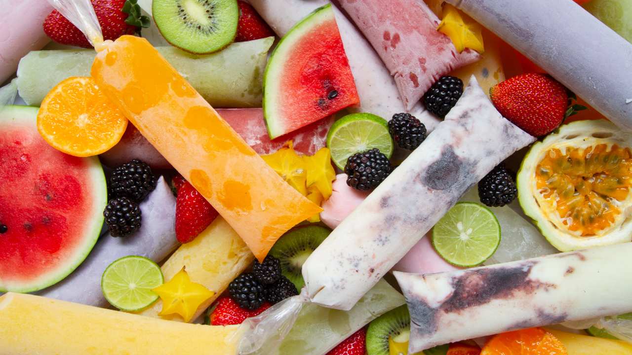 Picolés de frutas coloridos: morango, kiwi, laranja, limão e amora.