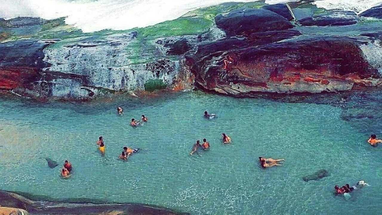 Piscina natural da Praia do Secreto no Rio de Janeiro, com pessoas nadando.