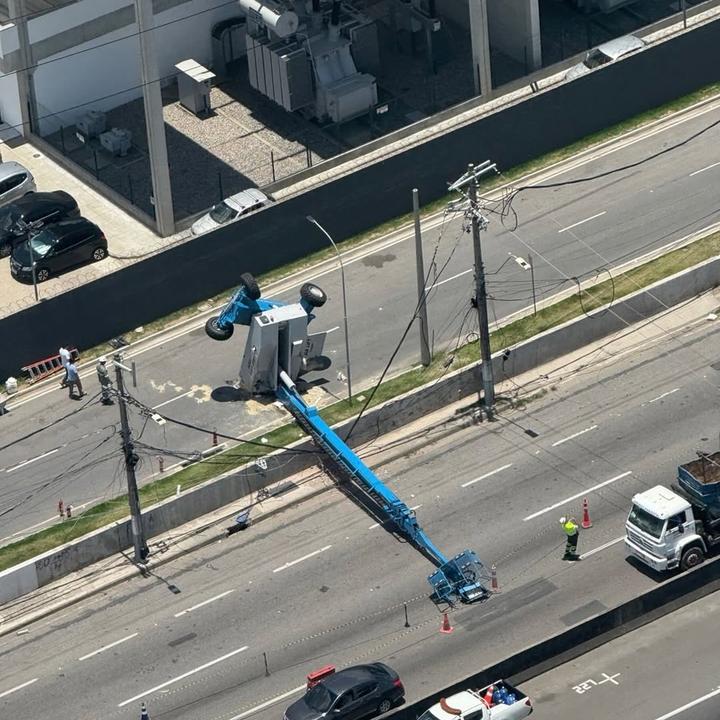 Plataforma elevatória tombada na Via Dutra, causando congestionamento em São João de Meriti.