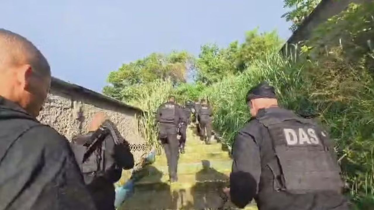 Polícia subindo escadas durante operação.
