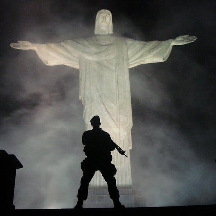 Policial em frente ao Cristo Redentor, simbolizando a segurança no Rio de Janeiro.