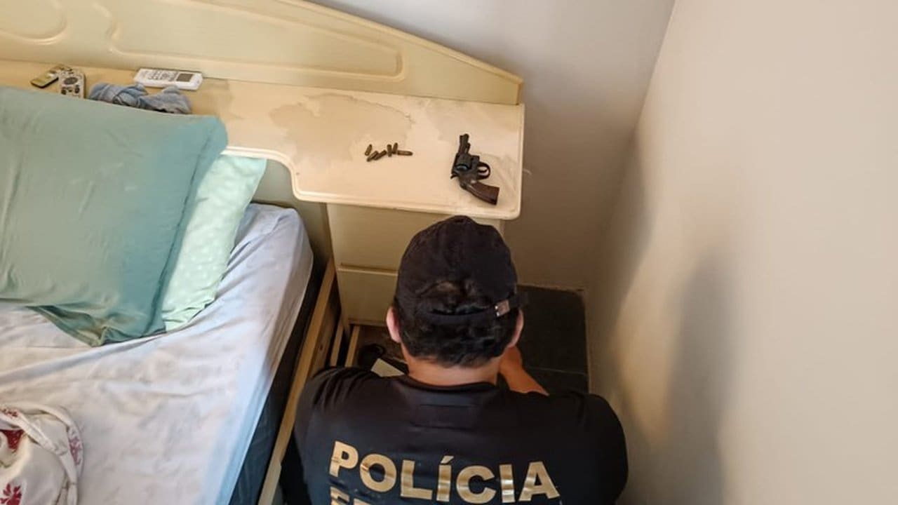 Policial federal investiga local com arma e munições durante operação.