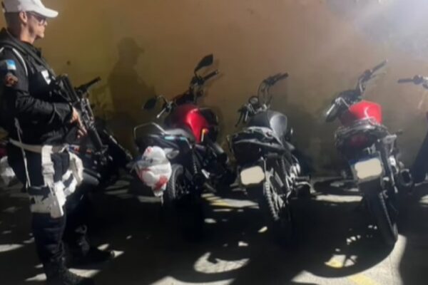 Policial militar com fuzil e motocicletas apreendidas em operação