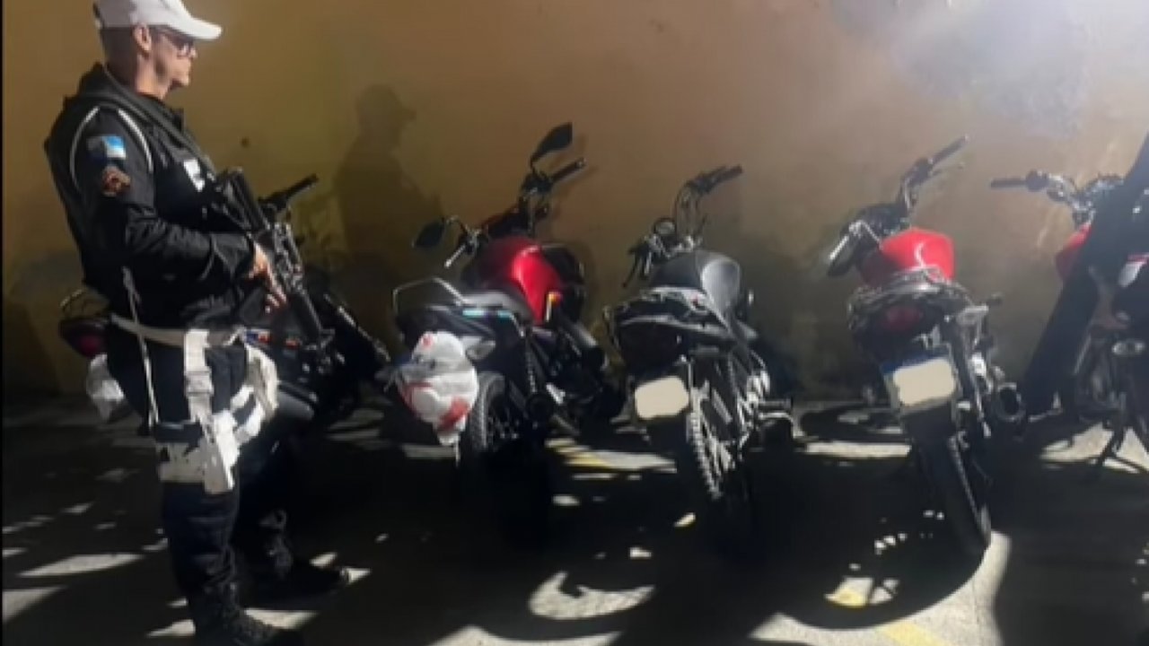 Policial militar com fuzil e motocicletas apreendidas em operação