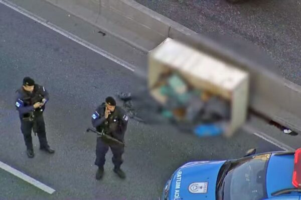 Policias militares isolam área de corpo encontrado na Avenida Brasil, Rio de Janeiro.