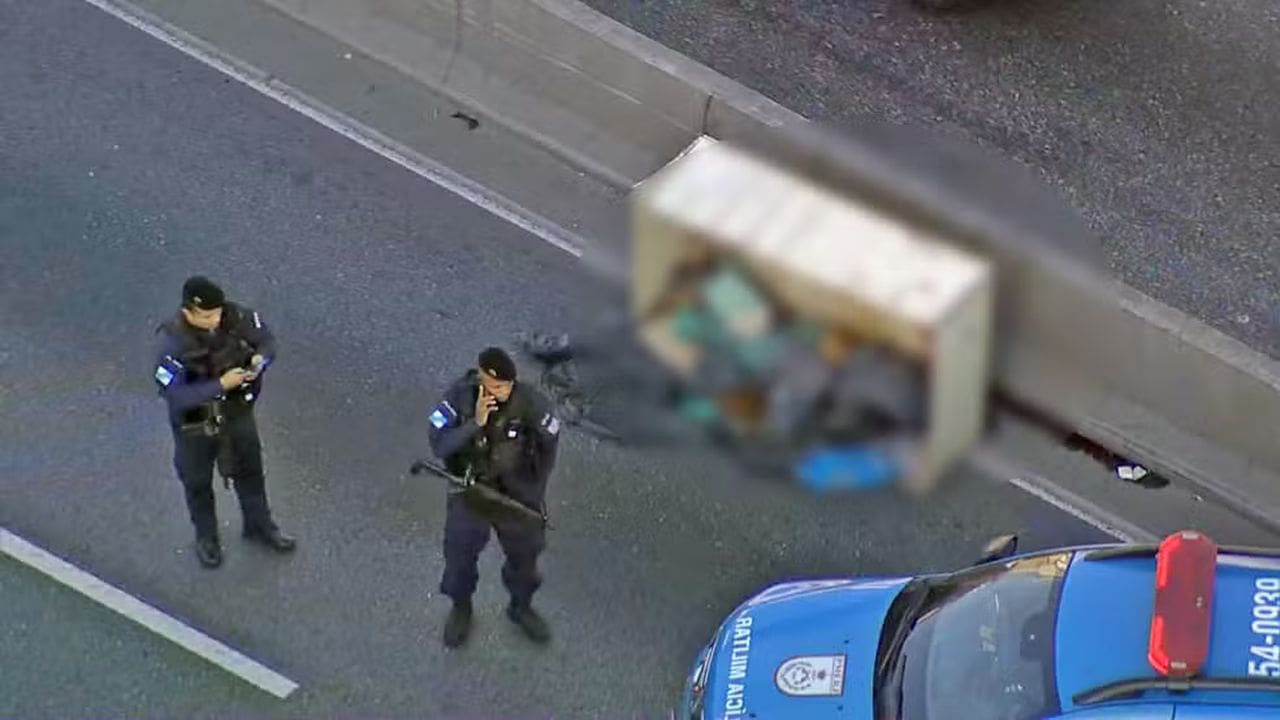 Policias militares isolam área de corpo encontrado na Avenida Brasil, Rio de Janeiro.