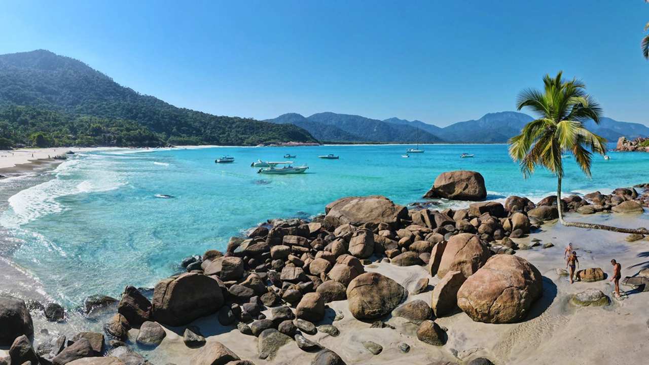 Praia do Aventureiro em Ilha Grande, com água azul turquesa e vegetação exuberante.
