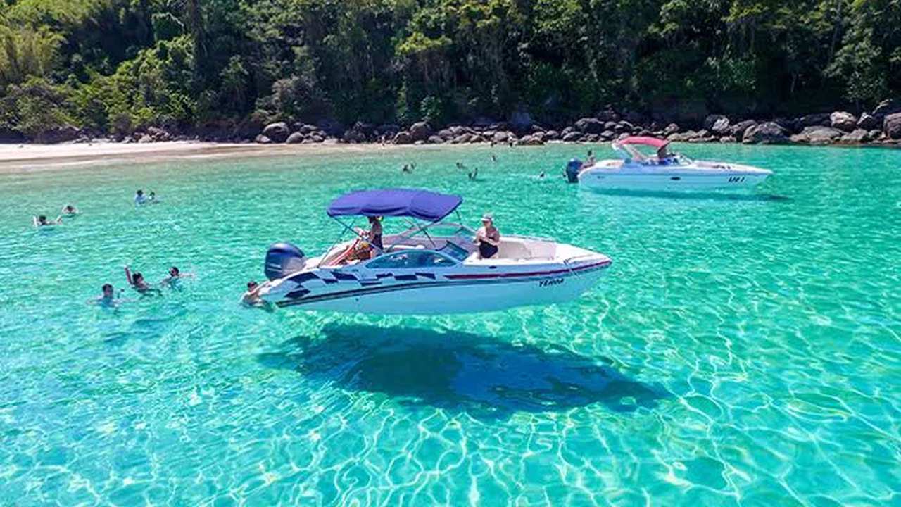 Praia do Dentista em Angra dos Reis: águas cristalinas e barcos ancorados.