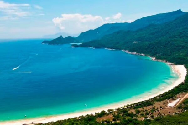 Praia paradisíaca de Ilha Grande, com águas cristalinas e montanhas ao fundo.