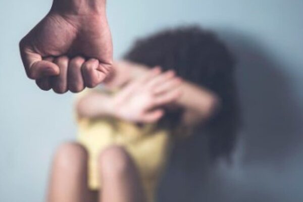 Punho prestes a atingir pessoa com as mãos levantadas para proteger o rosto, simbolizando violência.