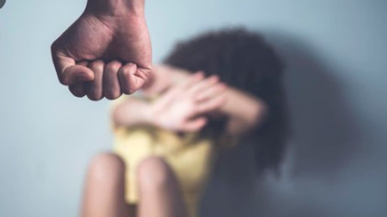 Punho prestes a atingir pessoa com as mãos levantadas para proteger o rosto, simbolizando violência.
