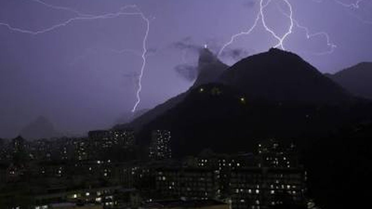 Raios iluminam a cidade do Rio de Janeiro durante tempestade com chuva forte.