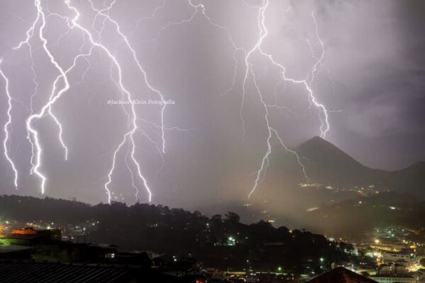Relâmpagos cortam o céu noturno sobre a cidade do Rio de Janeiro, em dia de alerta de chuva.