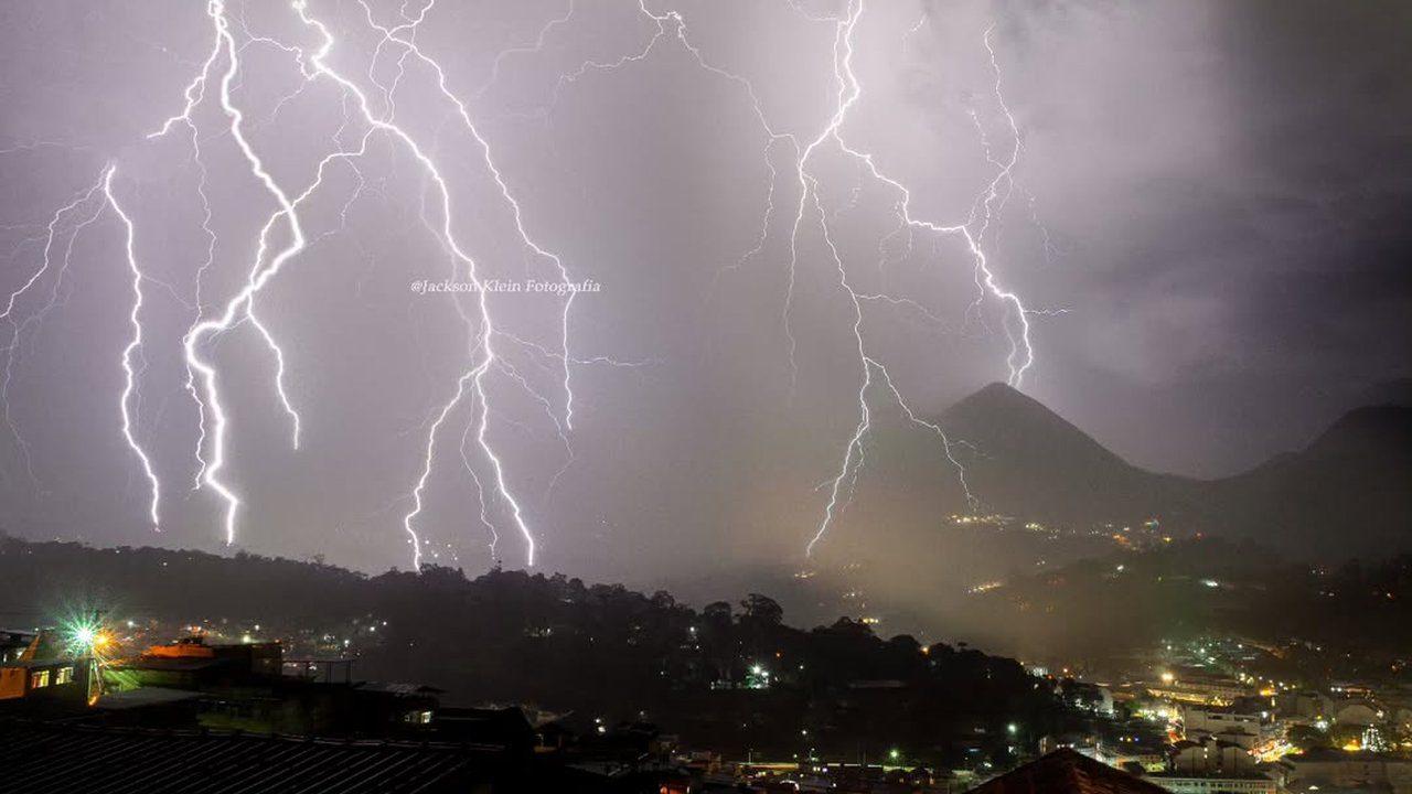 Relâmpagos cortam o céu noturno sobre a cidade do Rio de Janeiro, em dia de alerta de chuva.