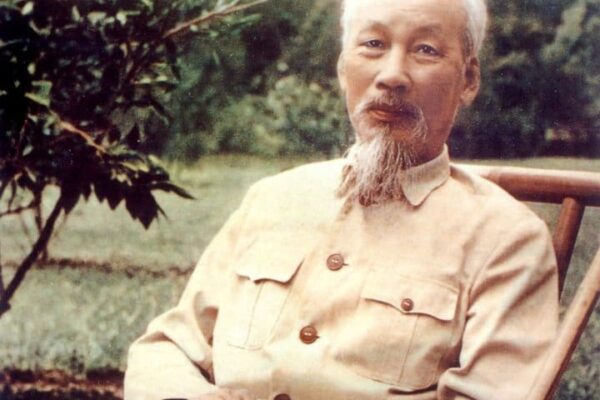 Retrato de Ho Chi Minh, figura histórica vietnamita, sentado em uma cadeira.