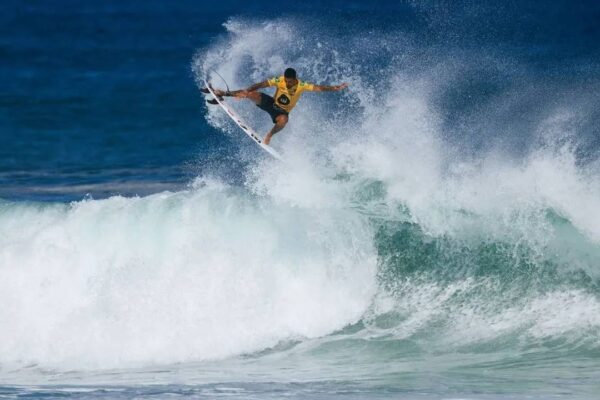 Surfista em Saquarema, cidade do Rio de Janeiro, realizando manobra radical na onda.