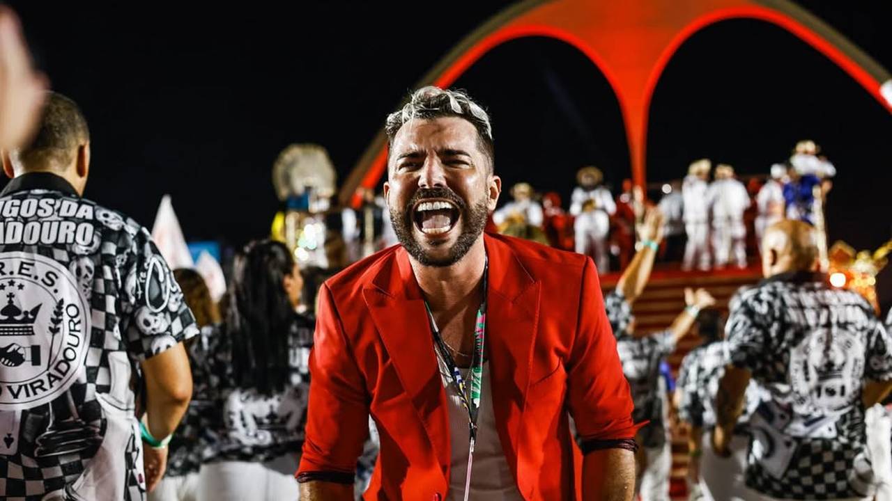 Tarcísio Zanon celebra vitória no Carnaval pela Viradouro, com blazer vermelho e sorriso vibrante.