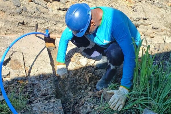 Técnico da Cedae trabalha em reparo de tubulação, em área de obras no Rio de Janeiro.
