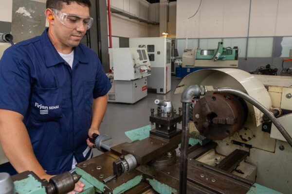 Técnico da Firjan SENAI trabalhando em máquina em oficina de Nova Friburgo.