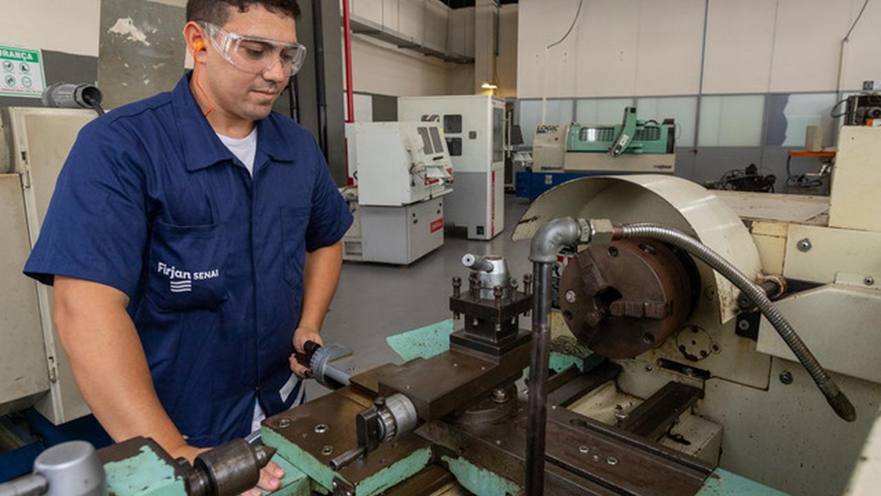 Técnico da Firjan SENAI trabalhando em máquina em oficina de Nova Friburgo.