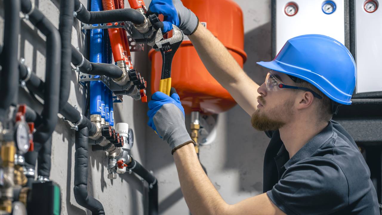 Técnico em instalações hidráulicas trabalha em tubulação