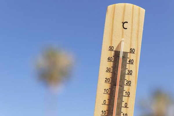 Termômetro de madeira mostrando alta temperatura em um dia ensolarado. Onda de calor.
