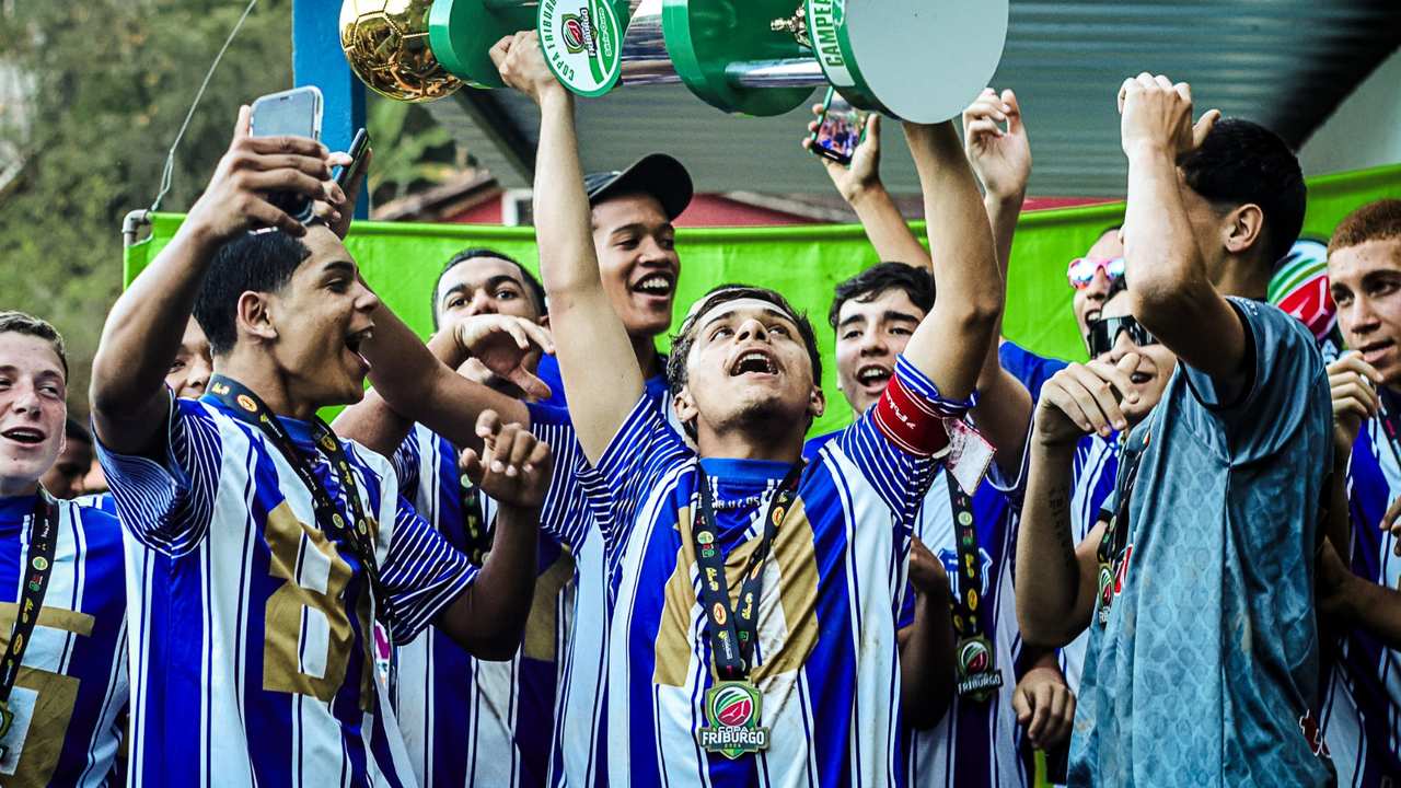 Time de futebol comemora a vitória e levanta a taça da Copa Friburgo