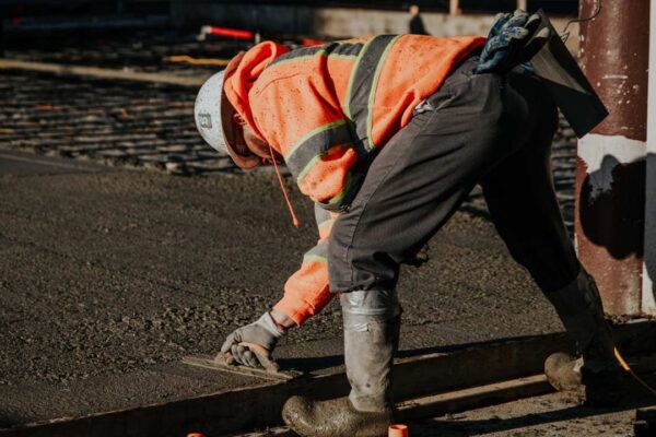 Trabalhador construindo, possivelmente em área urbana.