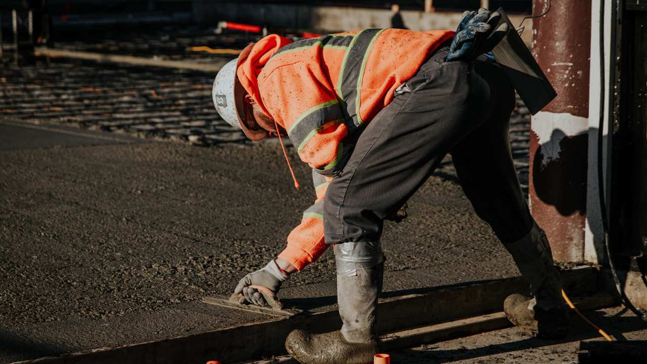 Trabalhador construindo, possivelmente em área urbana.