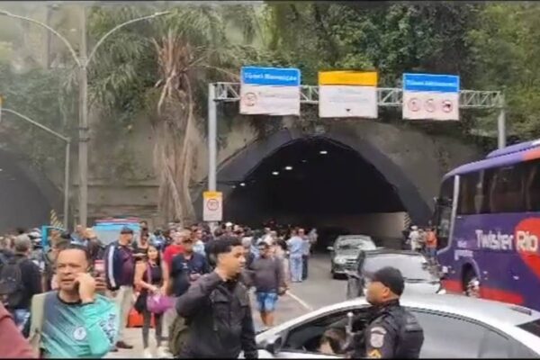 Túnel Rebouças interditado após incêndio em ônibus, com pessoas e veículos.