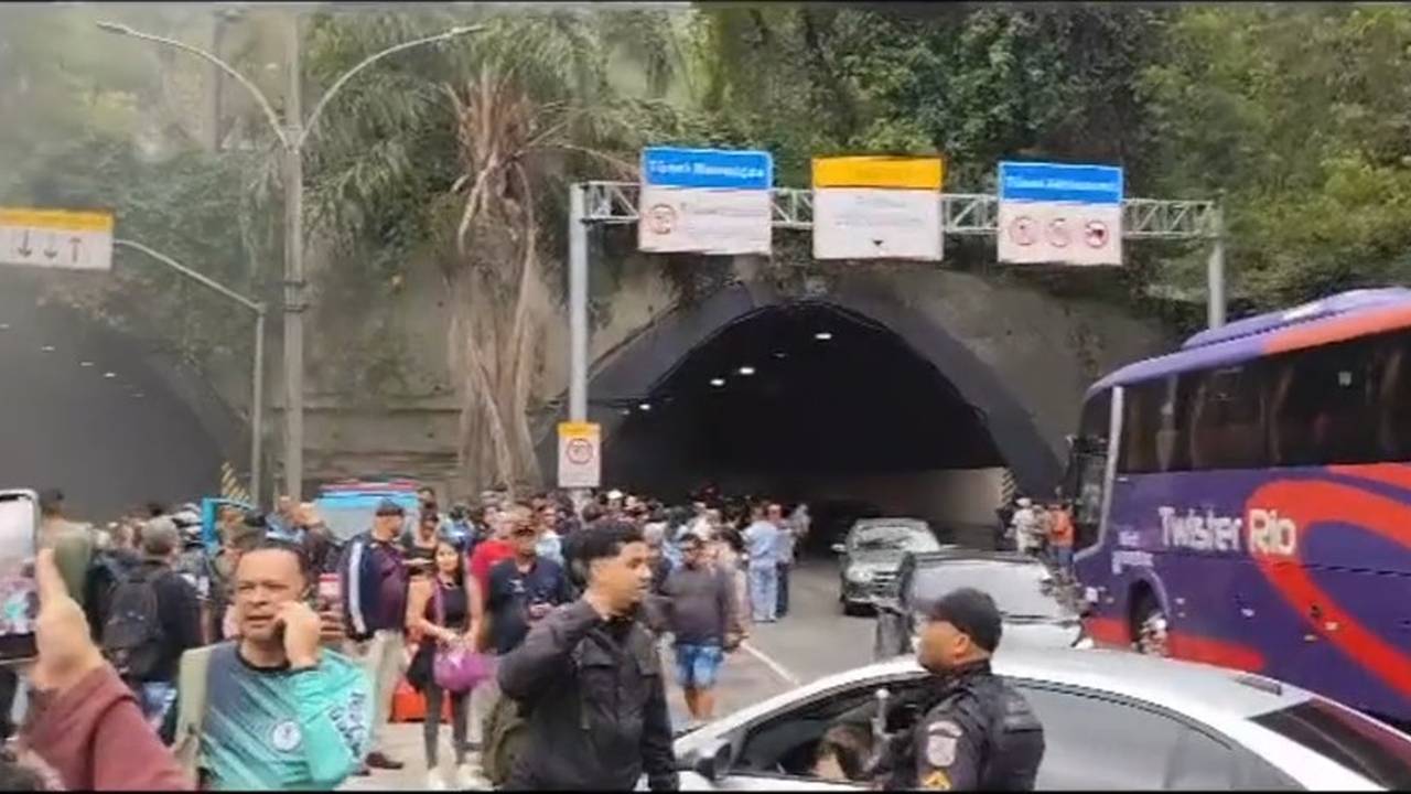 Túnel Rebouças interditado após incêndio em ônibus, com pessoas e veículos.