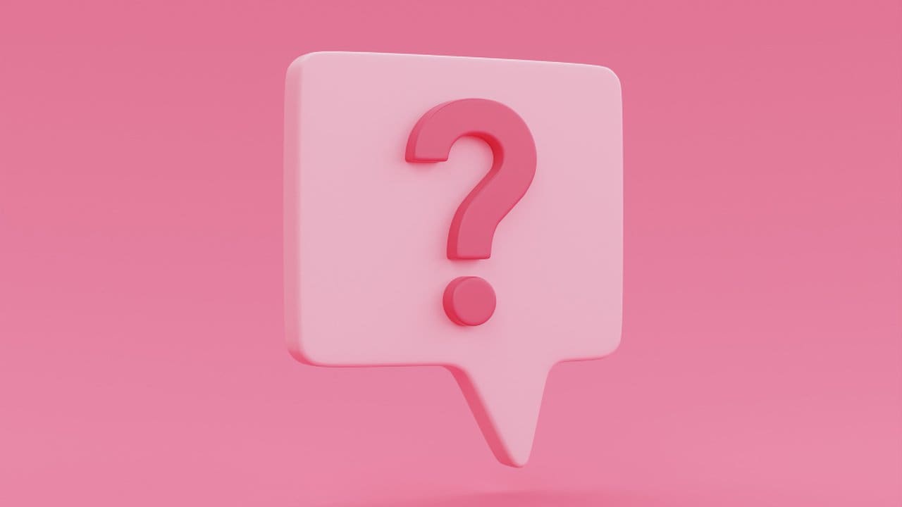 Um ponto de interrogação vermelho em um balão de fala branco sobre um fundo rosa.