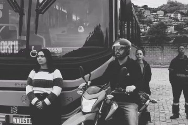 Vídeo da NOVA FAOL sobre pontos cegos em ônibus, com pessoas em frente a um ônibus e uma moto.