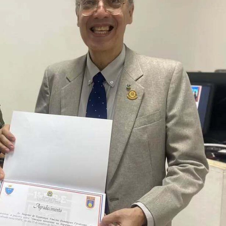 Vinícius Cavalcante sorrindo e segurando certificado de reconhecimento.