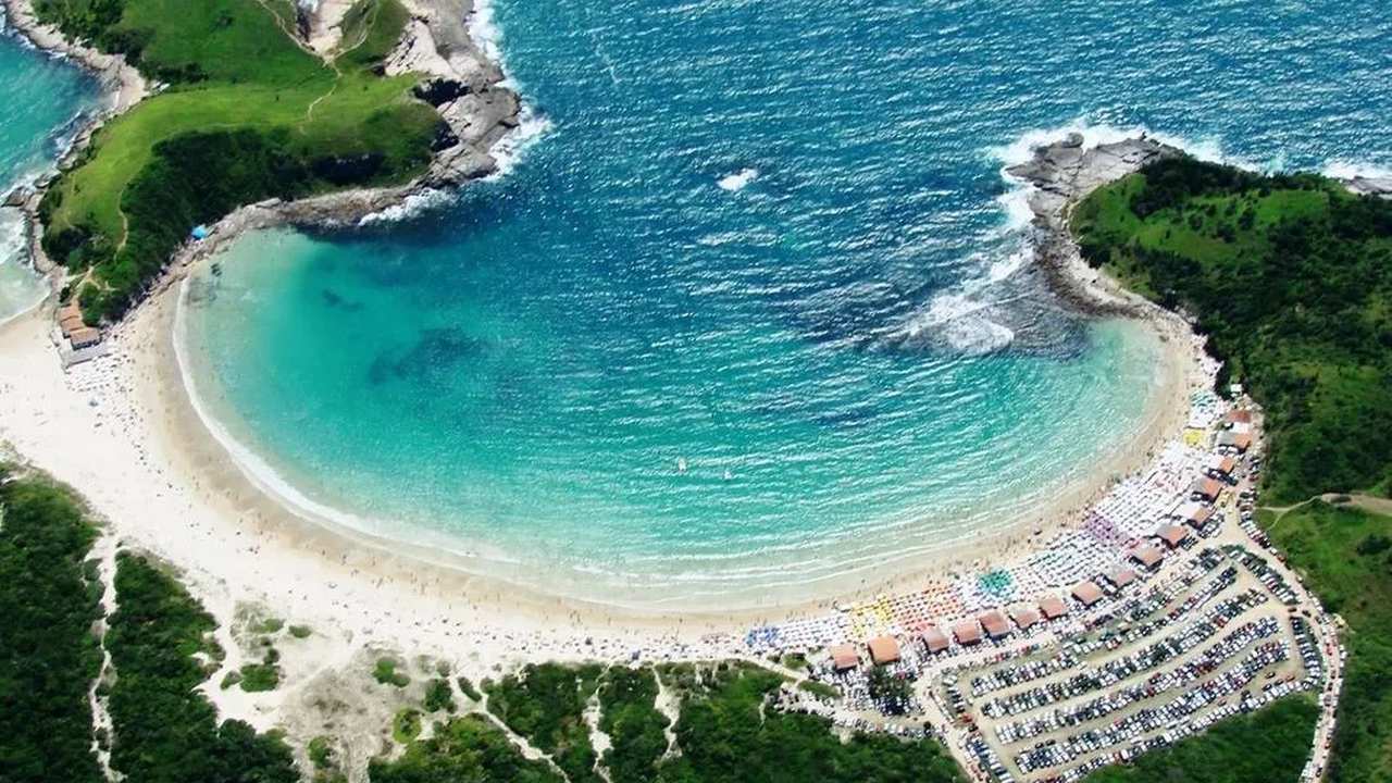 Vista aérea da Praia das Conchas em Cabo Frio, com águas cristalinas e areia clara.