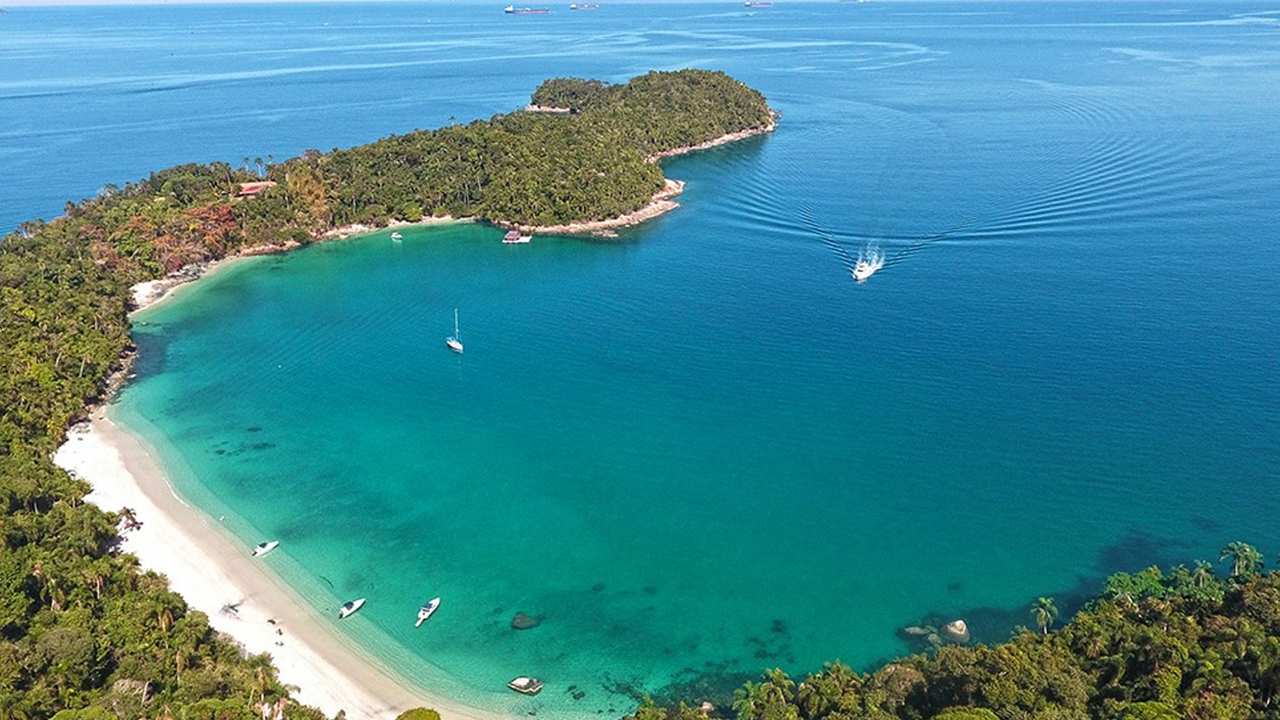 Vista aérea da Praia do Dentista, em Ilha Grande, com águas cristalinas e vegetação exuberante.