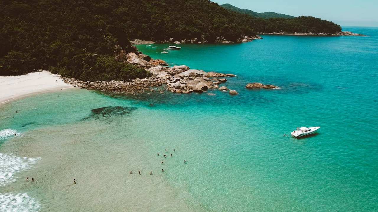 Vista aérea da Praia do Sono, com águas cristalinas, vegetação exuberante e barcos